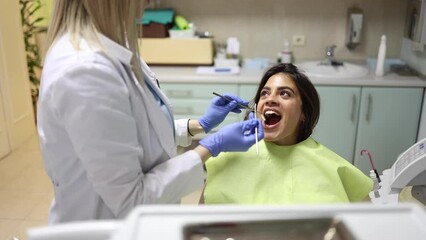 Wall Mural - Beautiful, young woman having a checkup at the dentist's