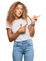 Poster - Beautiful caucasian teenager girl wearing casual white tshirt pointing aside worried and nervous with both hands, concerned and surprised expression