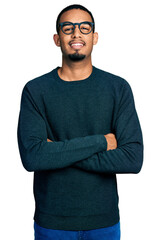 Poster - Young african american man wearing casual clothes and glasses happy face smiling with crossed arms looking at the camera. positive person.