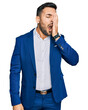 © Krakenimages.com - Young hispanic man wearing business jacket yawning tired covering half face, eye and mouth with hand. face hurts in pain.