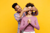Fototapeta  - Young couple two friend family man woman of African American ethnicity wear purple casual clothes together close eyes with hands play guess who or hide and seek isolated on plain yellow background.