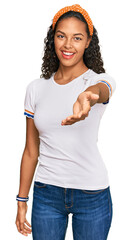 Poster - Young african american girl wearing casual clothes smiling cheerful offering palm hand giving assistance and acceptance.