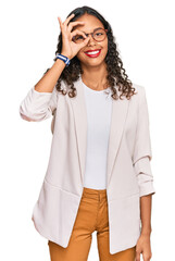 Canvas Print - Young african american girl wearing business clothes doing ok gesture with hand smiling, eye looking through fingers with happy face.