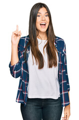 Sticker - Young brunette woman wearing casual clothes pointing finger up with successful idea. exited and happy. number one.