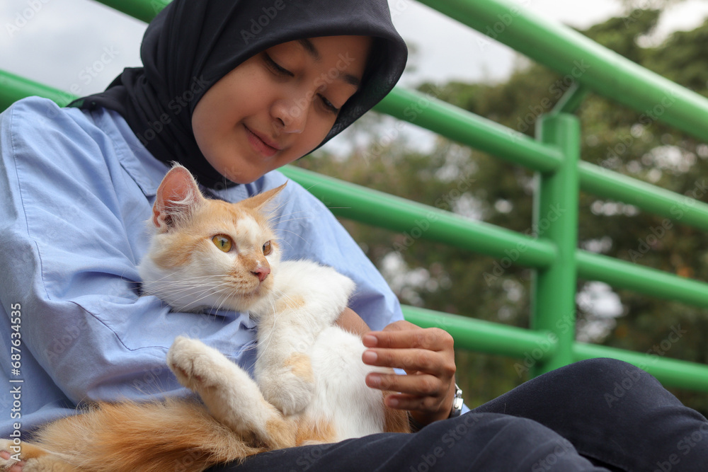outdoor-portrait-of-asian-hijab-woman-holding-and-giving-gentle-touch