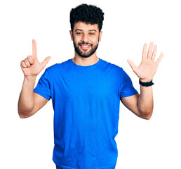 Poster - Young arab man with beard wearing casual blue t shirt showing and pointing up with fingers number seven while smiling confident and happy.