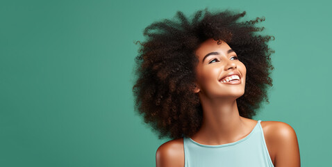 Wall Mural - Portrait of young happy black woman with Ultimate Afro hairstyle. Skin care beauty, skincare cosmetics. Isolated over green background.