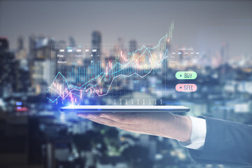 Aufkleber - Close up of businessman hand holding phone with creative candlestick graph on blurry night city background. Selling stocks, market and financial growth concept. Toned image. Double exposure.