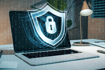 Poster - Close up of laptop at workplace with creative digital security padlock and shield hologram on blurry binary code background. Secure, safety and identification concept. 3D Rendering.