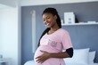 Cheerful pregnant young black woman