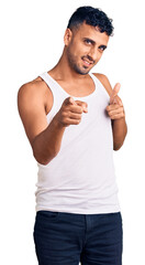 Poster - Young hispanic man wearing casual clothes pointing fingers to camera with happy and funny face. good energy and vibes.