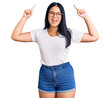 © Krakenimages.com - Young beautiful asian girl wearing casual clothes and glasses smiling amazed and surprised and pointing up with fingers and raised arms.