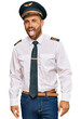 © Krakenimages.com - Handsome man with beard wearing airplane pilot uniform sticking tongue out happy with funny expression. emotion concept.