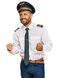 © Krakenimages.com - Handsome man with beard wearing airplane pilot uniform very happy and excited doing winner gesture with arms raised, smiling and screaming for success. celebration concept.