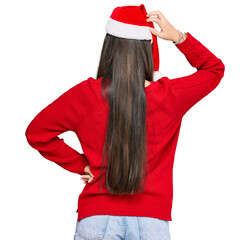 Sticker - Young chinese woman wearing christmas hat backwards thinking about doubt with hand on head