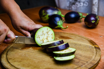 Wall Mural - Woman cutting eggplant on the cutting board
