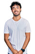 © Krakenimages.com - Hispanic young man with beard wearing casual white t shirt with a happy and cool smile on face. lucky person.
