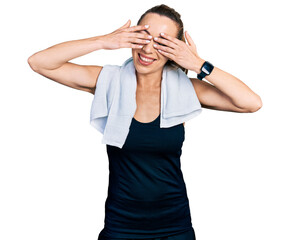 Wall Mural - Young caucasian woman wearing sportswear and towel covering eyes with hands smiling cheerful and funny. blind concept.