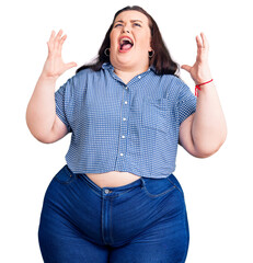 Wall Mural - Young plus size woman wearing casual clothes crazy and mad shouting and yelling with aggressive expression and arms raised. frustration concept.