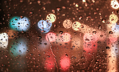 Wall Mural - View of the night street through a wet windshield.