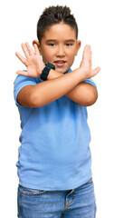 Wall Mural - Little boy hispanic kid wearing casual clothes rejection expression crossing arms doing negative sign, angry face