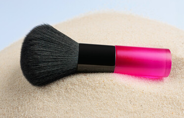 Highlighter make up brush on sand background