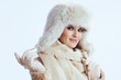 © Alliance - smiling stylish woman in winter coat and fur hat on white
