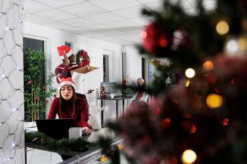 Wall Mural - Employee starting new job in festive decorated office, greeting coworkers. Worker happy after accepting new company position, meeting colleagues for first time in Christmas ornate workspace