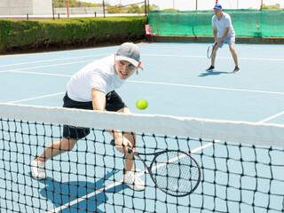 Wall Mural - Man on serve with tenis racket and dressed in white t-shirt, black shorts and white shoes.