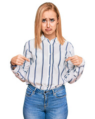 Wall Mural - Beautiful caucasian woman wearing casual clothes pointing down looking sad and upset, indicating direction with fingers, unhappy and depressed.