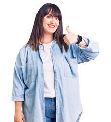 Sticker - Young plus size woman wearing casual clothes smiling happy and positive, thumb up doing excellent and approval sign