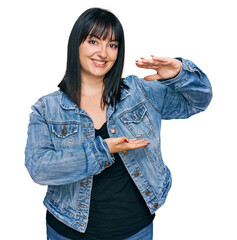 Canvas Print - Young hispanic woman wearing casual clothes gesturing with hands showing big and large size sign, measure symbol. smiling looking at the camera. measuring concept.