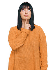 Poster - Young hispanic woman wearing casual clothes thinking concentrated about doubt with finger on chin and looking up wondering