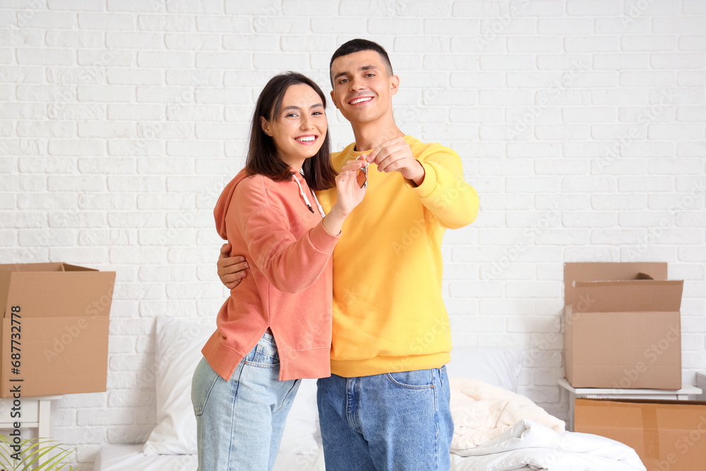 Happy young couple with key in their new flat