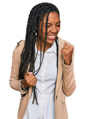 Wall Mural - African american woman wearing business jacket celebrating surprised and amazed for success with arms raised and eyes closed. winner concept.