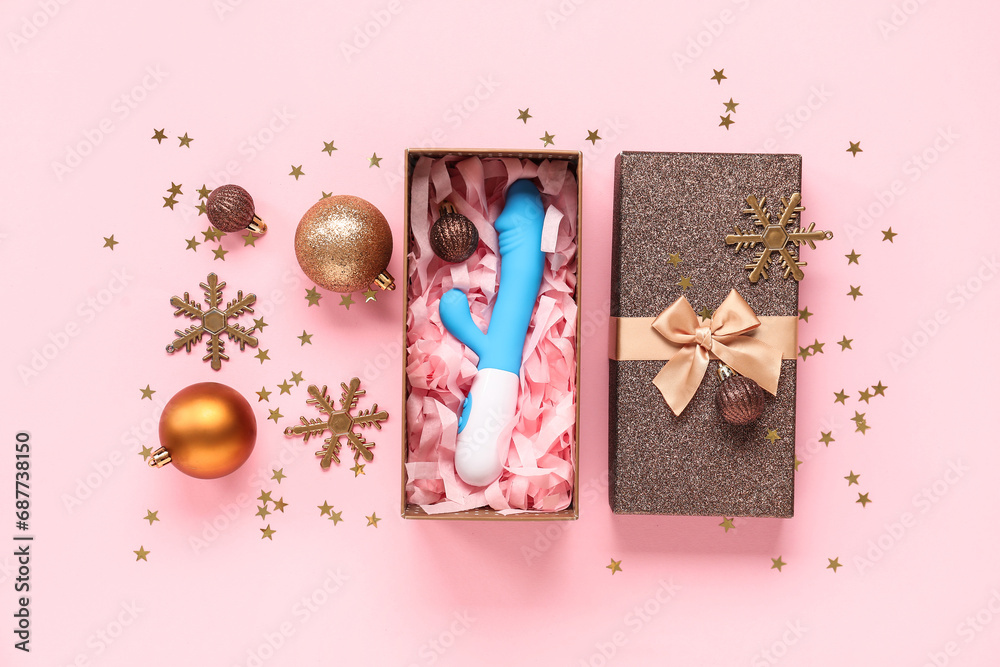 Gift box with vibrator and beautiful Christmas decorations on pink background