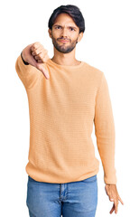 Poster - Handsome hispanic man wearing casual sweater looking unhappy and angry showing rejection and negative with thumbs down gesture. bad expression.