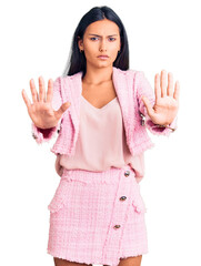 Canvas Print - Young beautiful latin girl wearing business clothes doing stop gesture with hands palms, angry and frustration expression