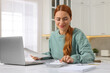 © New Africa - Woman calculating taxes at table in kitchen