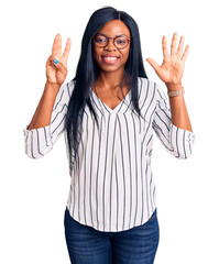 Sticker - Young african american woman wearing casual clothes and glasses showing and pointing up with fingers number eight while smiling confident and happy.