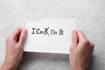 motivation concept. woman holding paper with changed phrase from i can't do it into i can do it by c