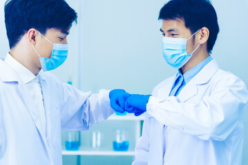 Two asian scientist men fist bump team partner shake hands together. Teamwork Men science chemistry research working success in laboratory. Close up hand pharmaceutical science corporate partnership