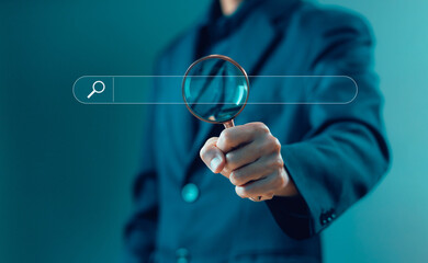 Wall Mural - businessman holding a magnifying glass shows the search bar. concept of a website to find a job and 