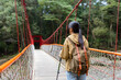Woman go hiking and walk along the suspension bridge