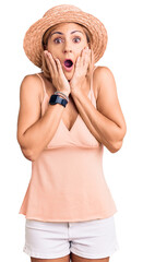 Sticker - Young blonde woman wearing summer hat afraid and shocked, surprise and amazed expression with hands on face