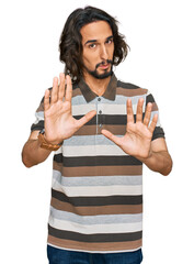 Young hispanic man wearing casual clothes moving away hands palms showing refusal and denial with afraid and disgusting expression. stop and forbidden.