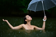 Woman With Umbrella In Lake Sea Water. Summer Rain. Rainy Weather. Rain Rain Go Away. Rain In Summer. Sexy Woman Sensually Relaxing In Swimming Pool. Recreation Wellness And Wellbeing. Wet Naked Body.