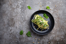 Spaghetti With Spinach, Pine Nuts And Parmesan Cheese On A Plate On A Gray Table