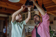 © Halfpoint - Father explaining led bubls to son, teaching him about energy efficiency, longevitiy and environmental impact. Changing bulbs at home.