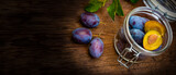 Fototapeta Kuchnia - plums in a bottle on a wooden table